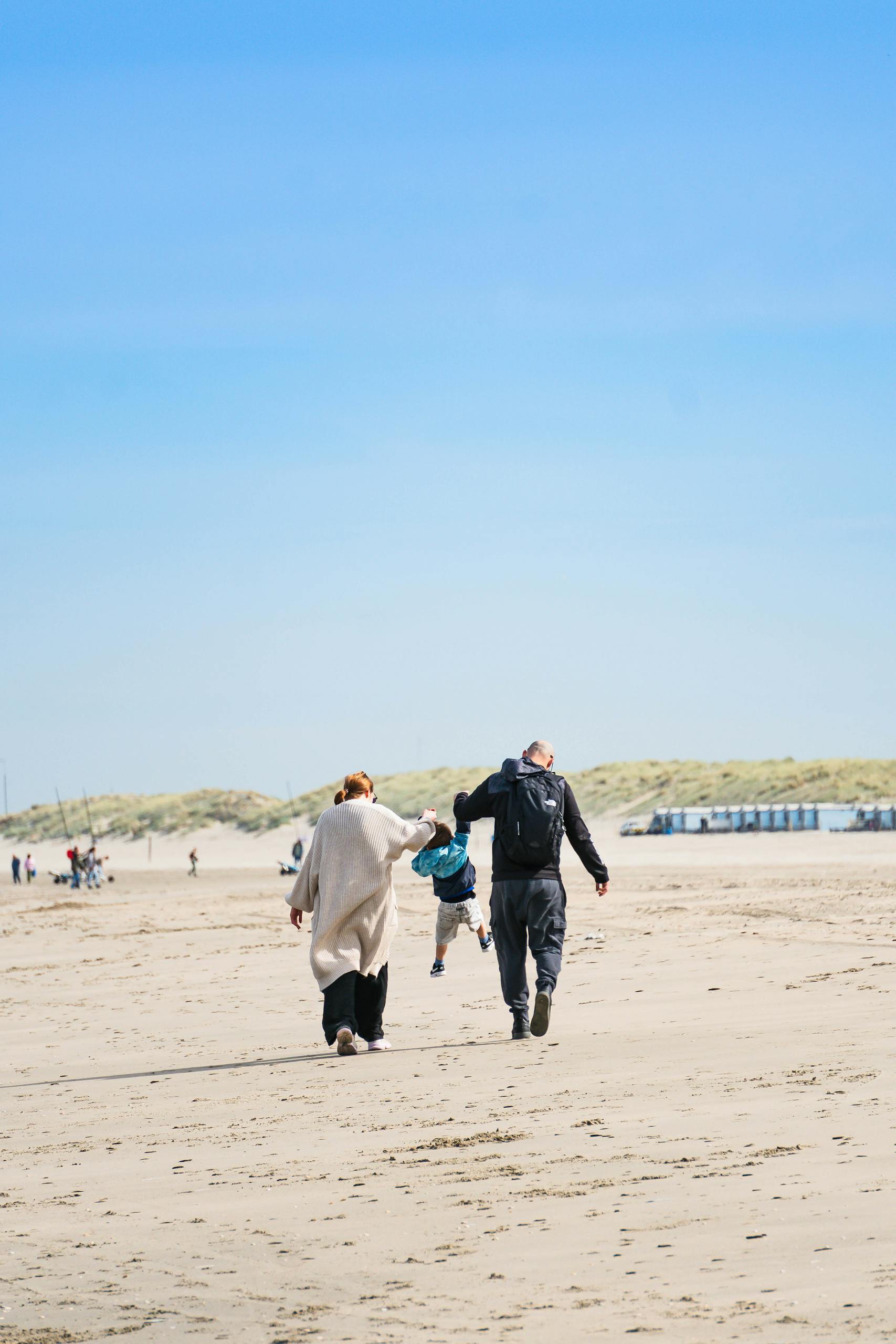 Familie wandelt op het strand van Noordwijk tijdens de Dag van het Strand